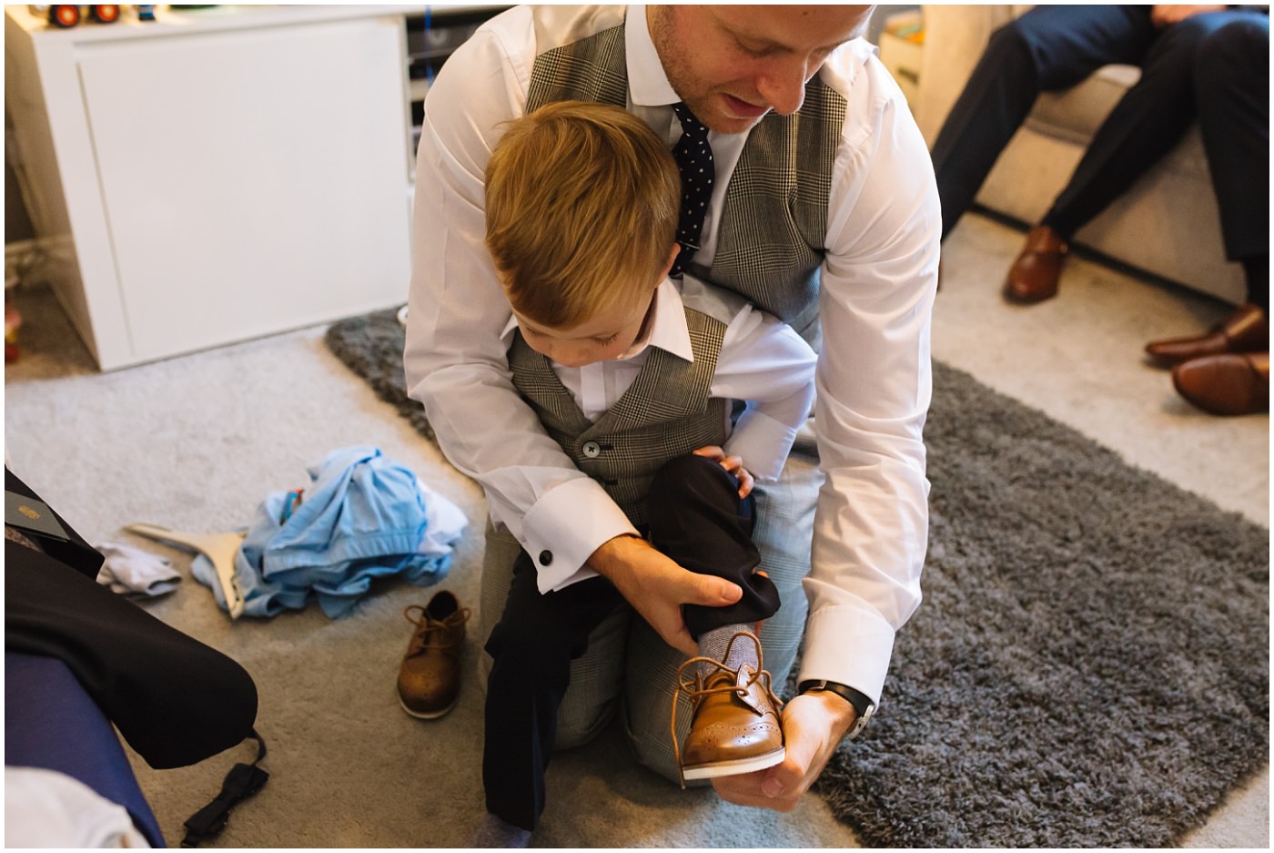 groom helps son with shoes