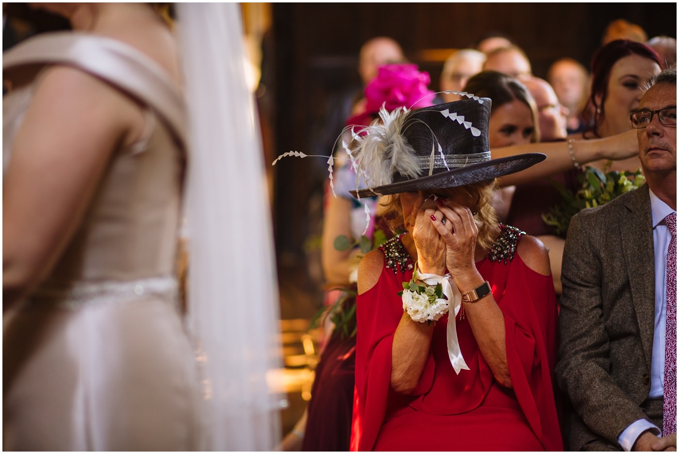 mother of the bride wipes away a tear during emotional samlesbury hall wedding