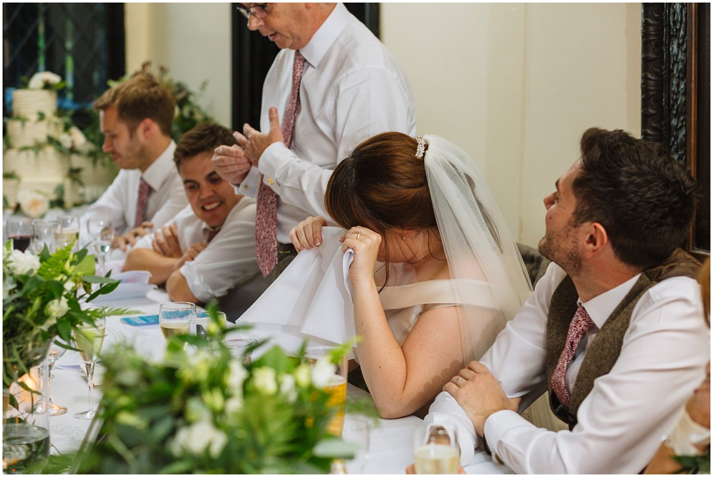 bride wipes a tear from her eye during her dads speech