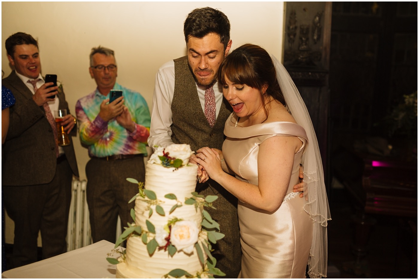 bride and groom cut the cake at samlesbury hall wedding