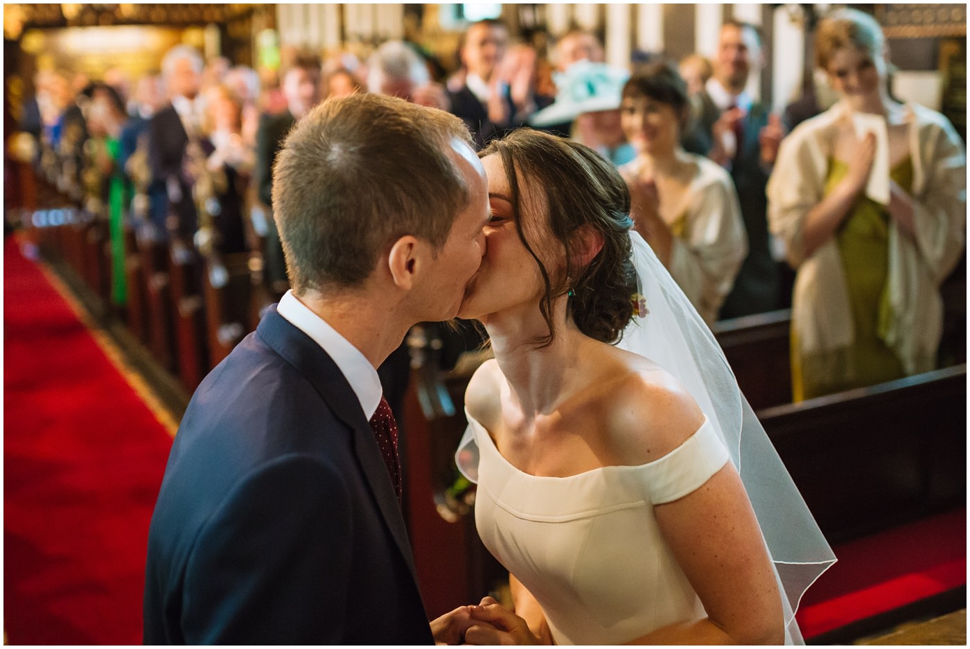 bride and groom kiss during cheshire church ceremony