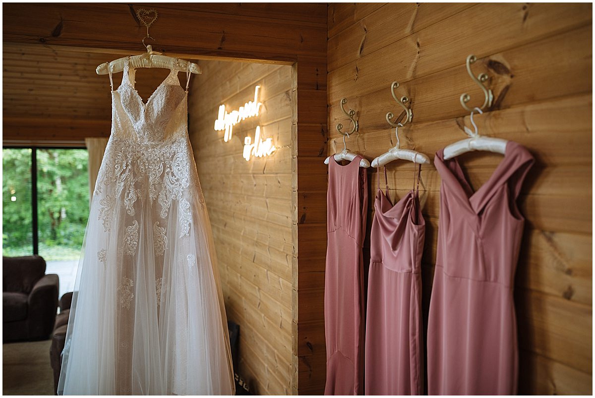 Wedding dress and bridesmaids dresses hang in the bridal room at styal lodge